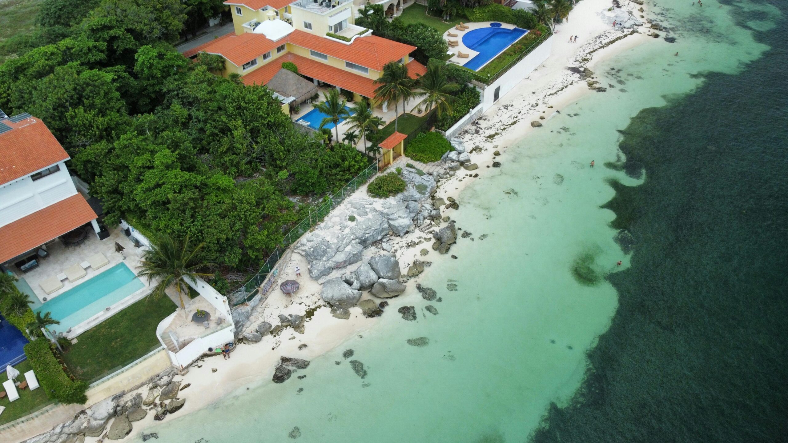 pexels-photo-18224158-18224158 Tropical coastal villas with pools overlooking a serene shoreline, ideal for vacation imagery.