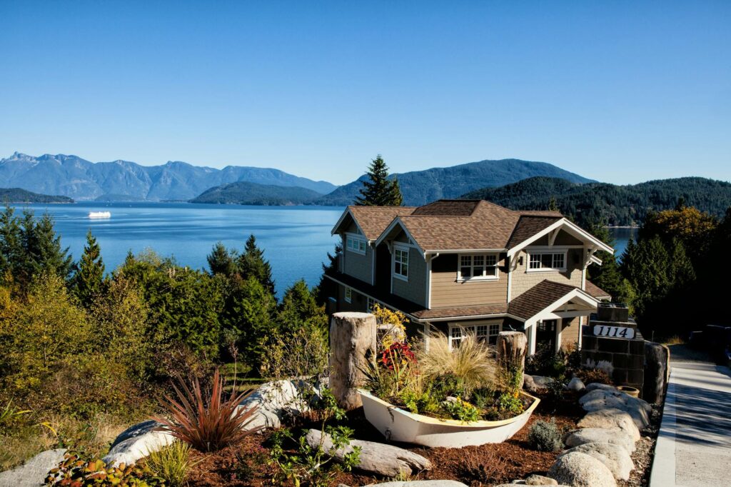 pexels-photo-262405-262405 Scenic view of a charming house by the lake surrounded by mountains and lush greenery.